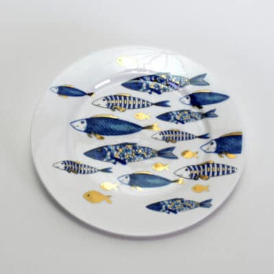runder Teller aus weißen Porzellan mit Motiv Fischen in blau und gold