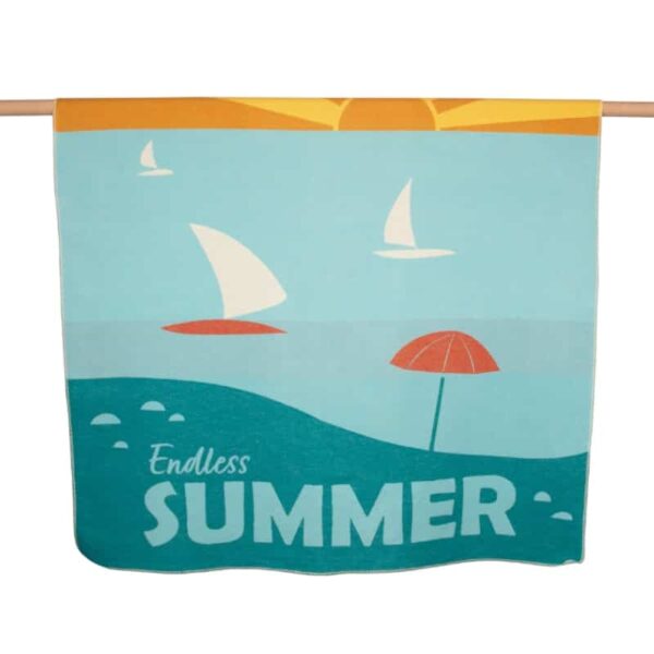 Decke Silvretta mit dem Text Endless Summer und einem Strandmotiv mit Sonnenschirm und Segelbooten auf dem Meer der Marke Fussenegger