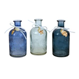 drei kleine Dekoflaschen in verschiedenen Blautönen. An dekorativen Bändchen gebunden um den Flaschenhals hängen zwei kleine Muscheln.